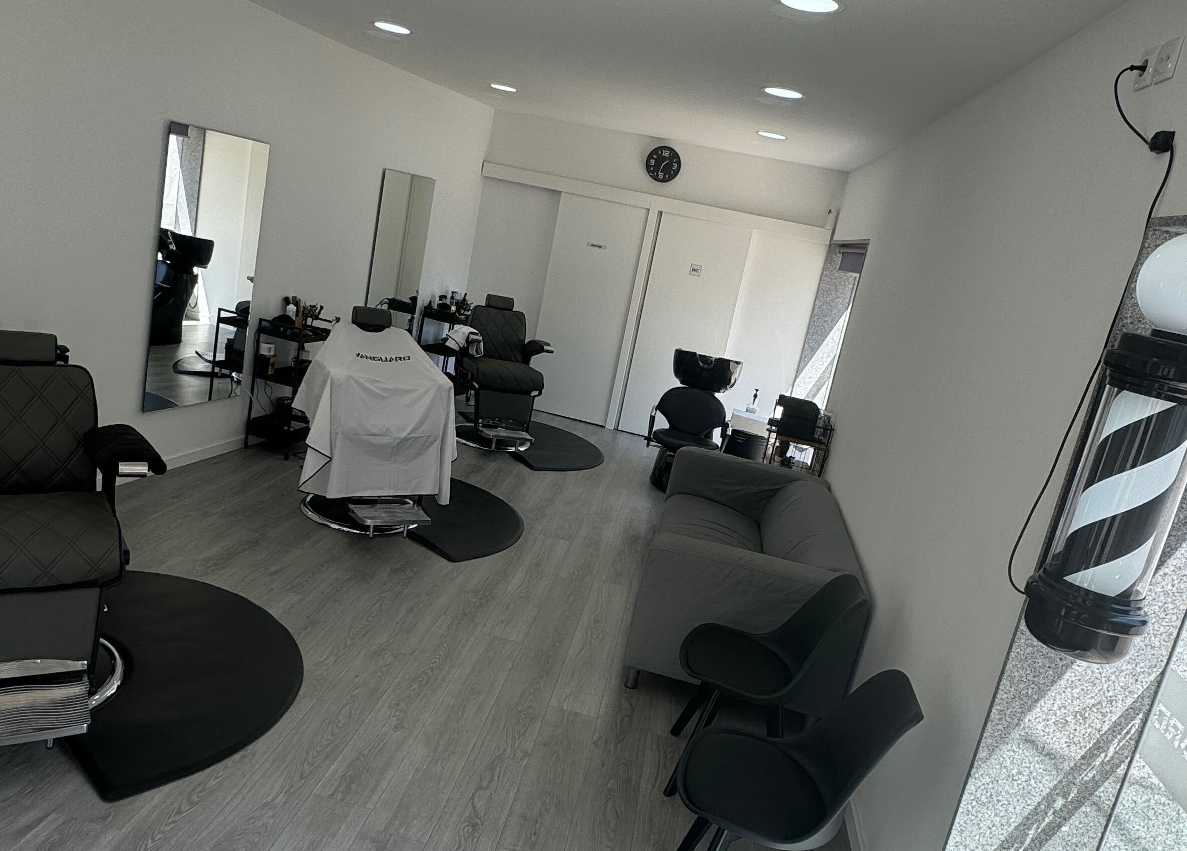 Interior moderno da Araujo Barbershop em Ílhavo, Aveiro, PT, com cadeiras de barbeiro e decoração elegante.