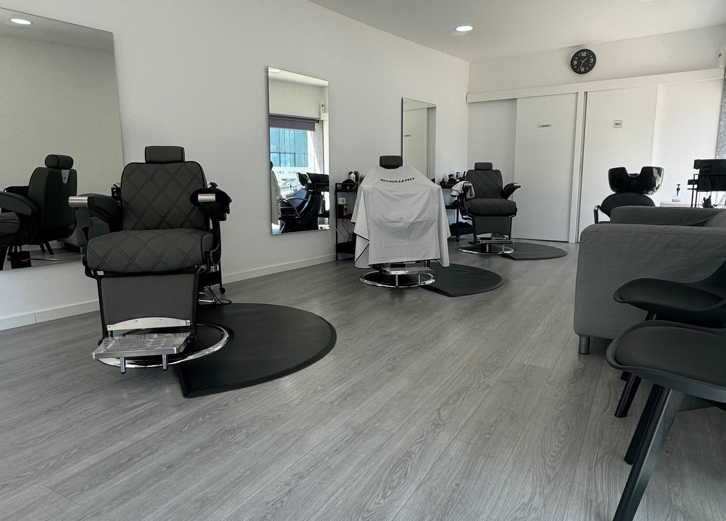 Sala moderna da Araujo Barbershop, Ílhavo, Aveiro, PT, apresentando cadeiras de barbear refinadas e elegantes.