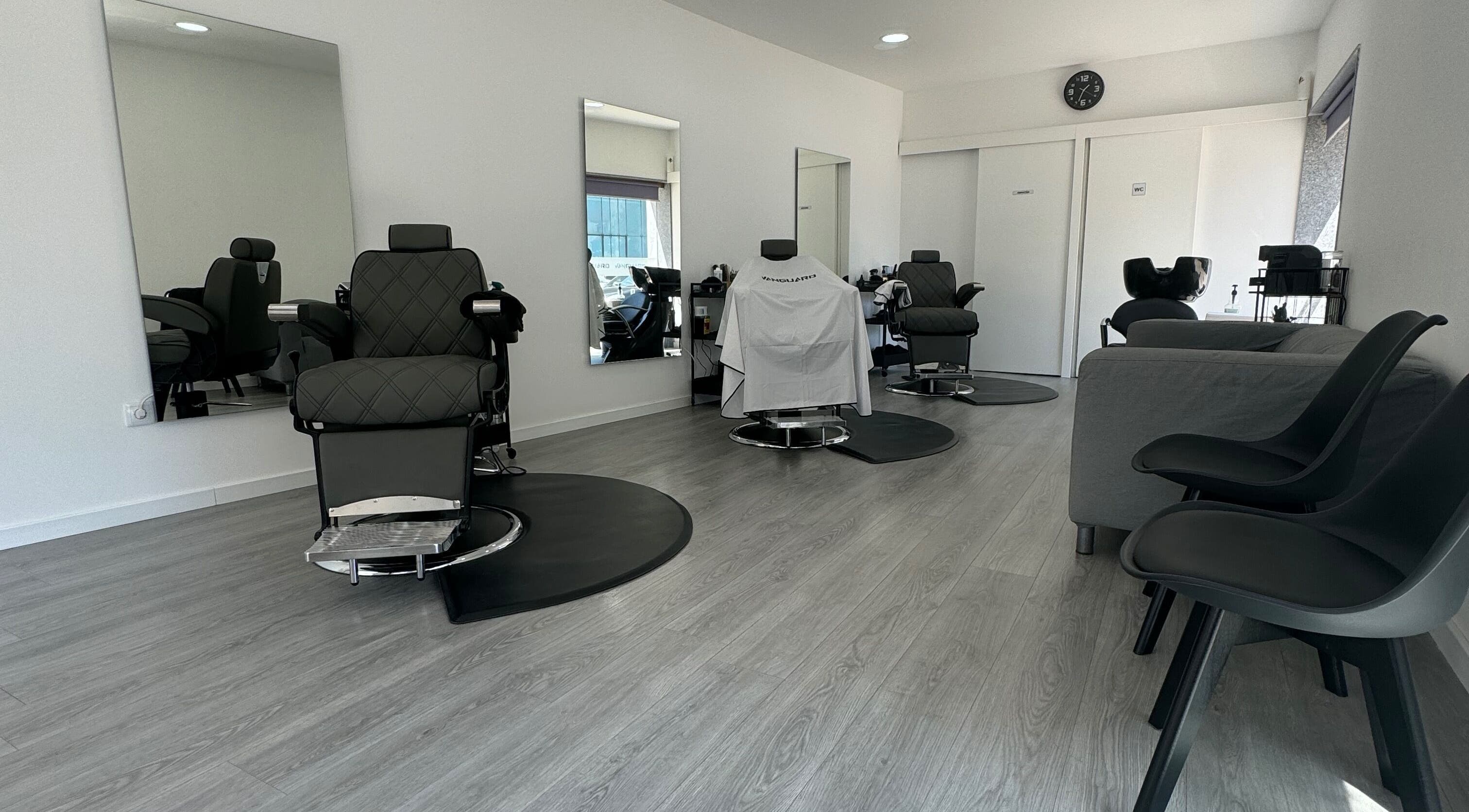 Sala moderna da Araujo Barbershop, Ílhavo, Aveiro, PT, apresentando cadeiras de barbear refinadas e elegantes.