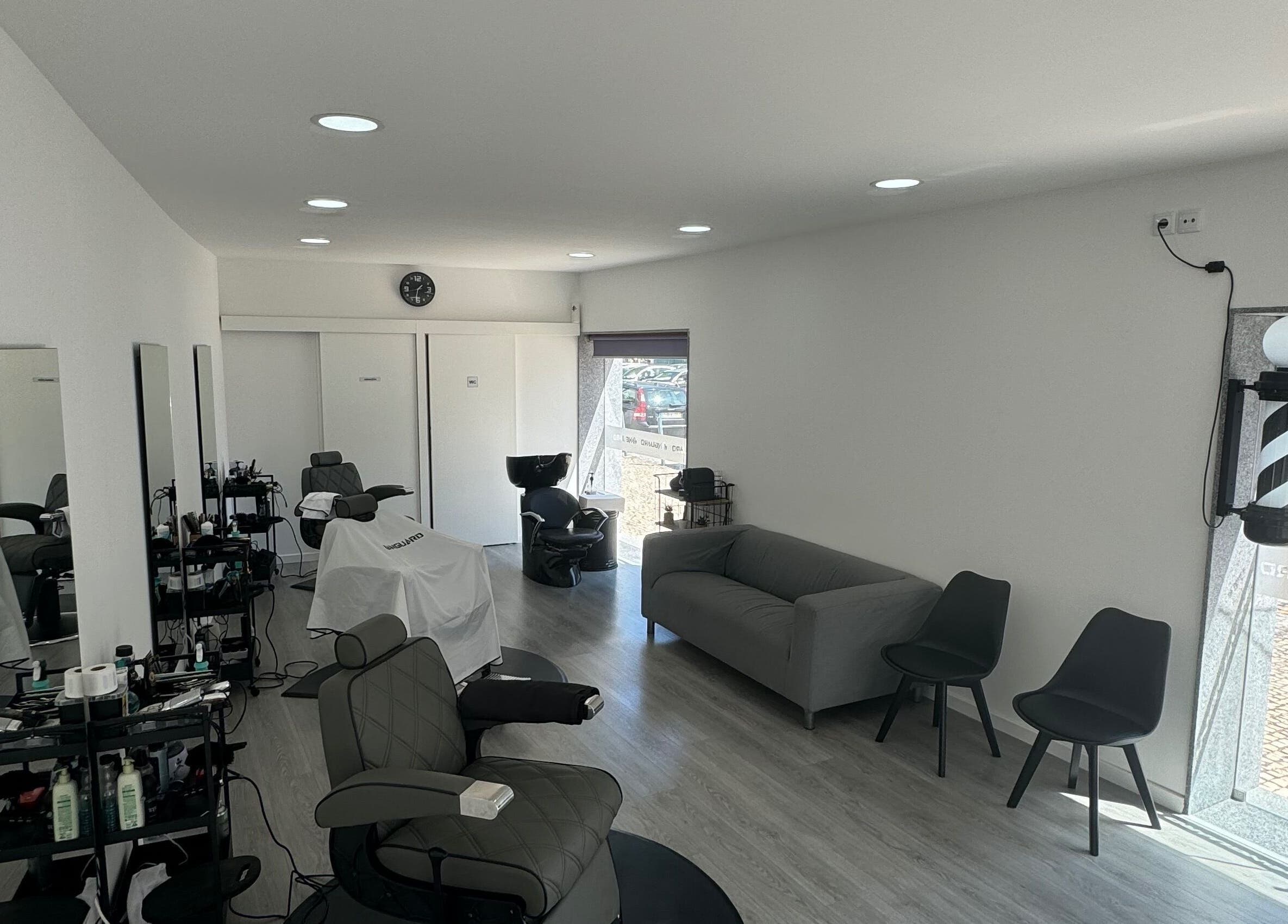 Interior moderno do Araujo Barbershop em Ílhavo, Aveiro, PT com cadeiras confortáveis e decoração elegante.