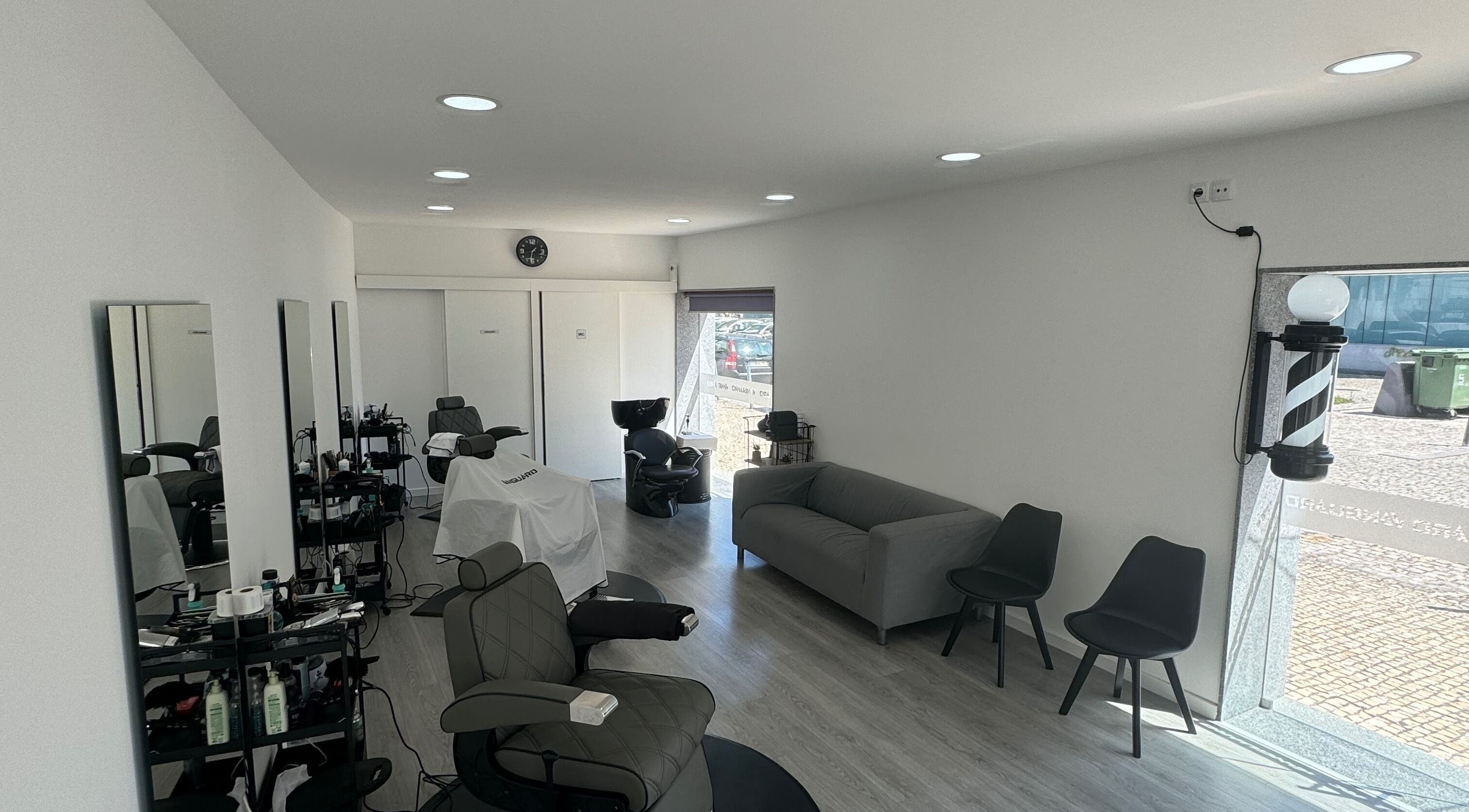 Interior moderno do Araujo Barbershop em Ílhavo, Aveiro, PT com cadeiras confortáveis e decoração elegante.