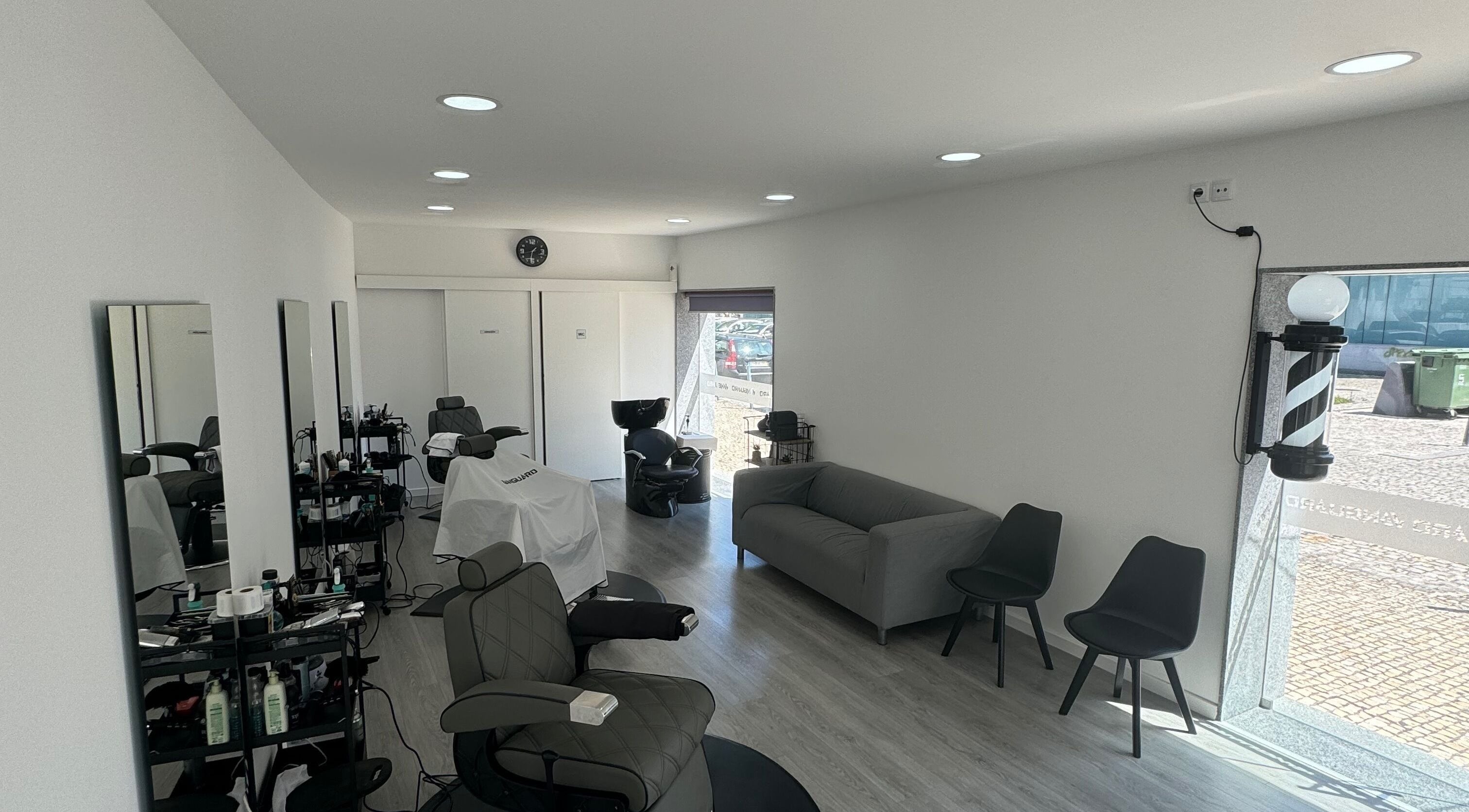 Interior moderno do Araujo Barbershop em Ílhavo, Aveiro, PT com cadeiras confortáveis e decoração elegante.