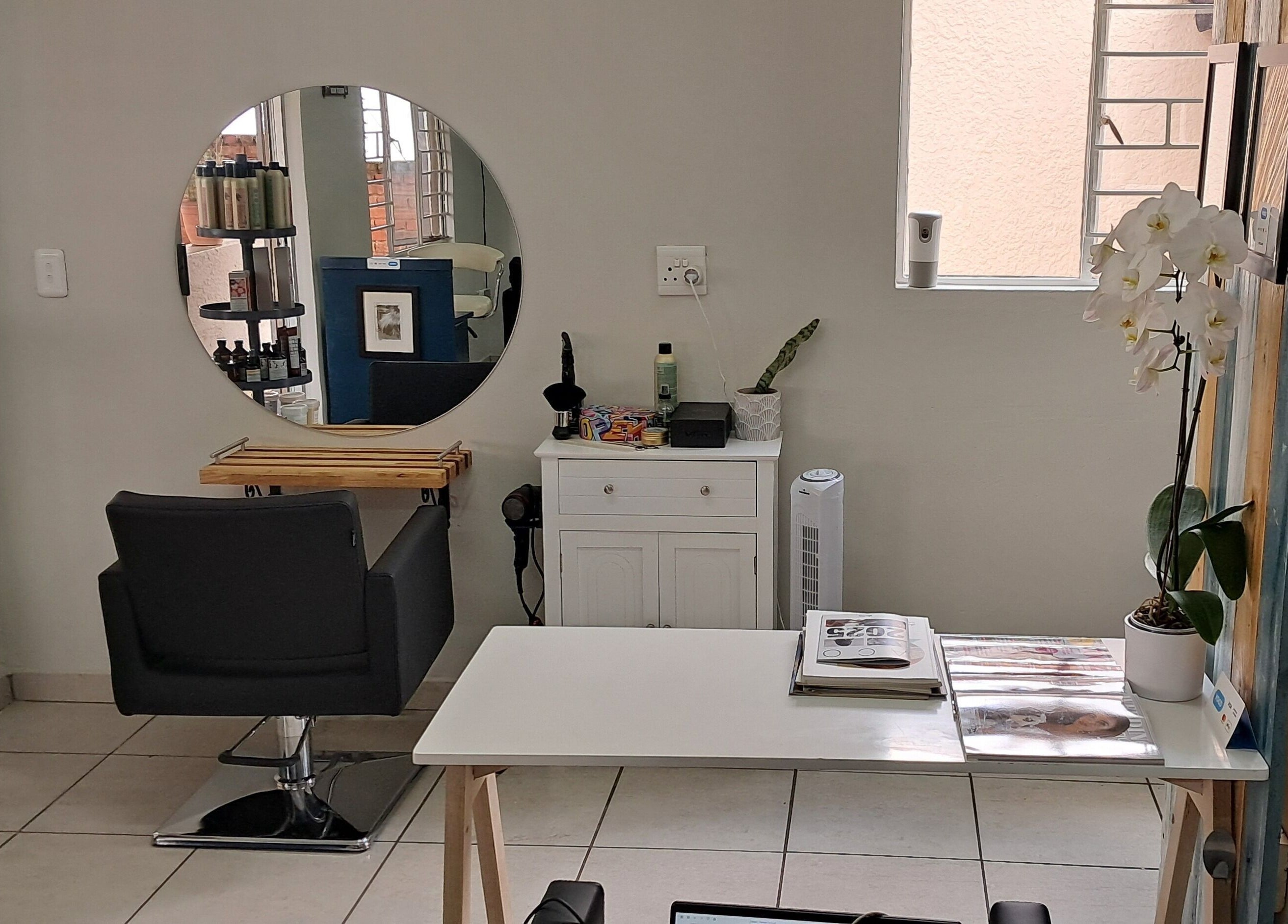 Stylish hair station at Hairon116 in Roodepoort, Gauteng, ZA with mirror, chair, and beauty products.
