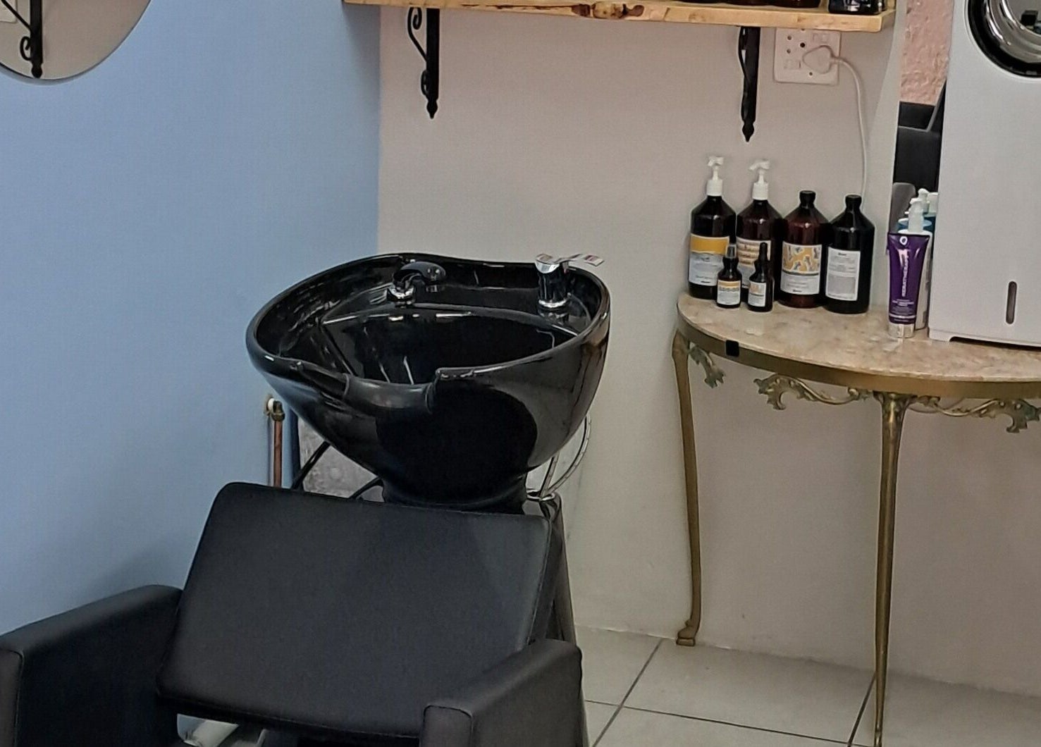 Elegant shampoo station at Hairon116, Roodepoort, Gauteng, ZA, featuring a sleek washbasin and product display.