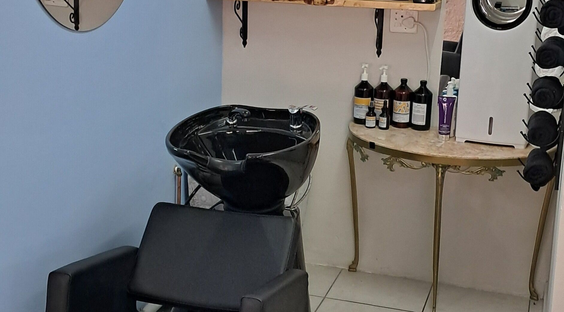 Elegant shampoo station at Hairon116, Roodepoort, Gauteng, ZA, featuring a sleek washbasin and product display.