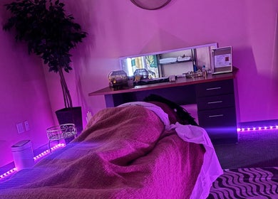 Calming massage room at Ashley's Healing Massage in Fort Lauderdale, Florida, US with ambient purple lighting.