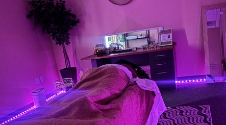 Calming massage room at Ashley's Healing Massage in Fort Lauderdale, Florida, US with ambient purple lighting.