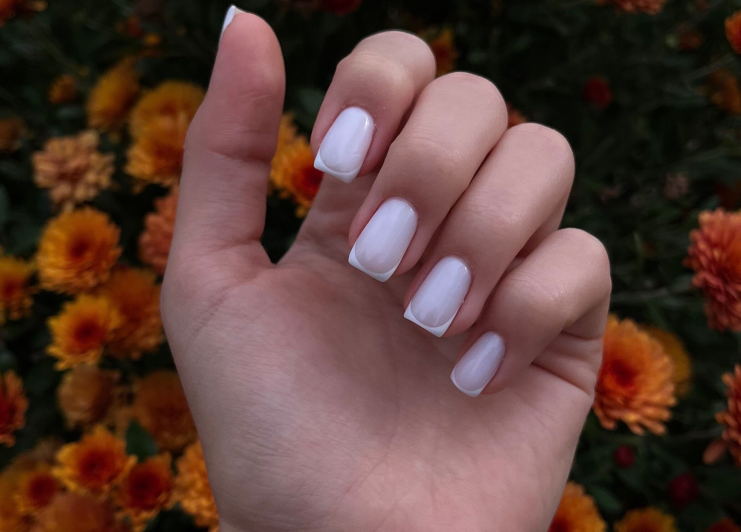 Елегантен френски маникюр в Bri Art Studio, Варна, Варна, BG, с красив фон от цветя.