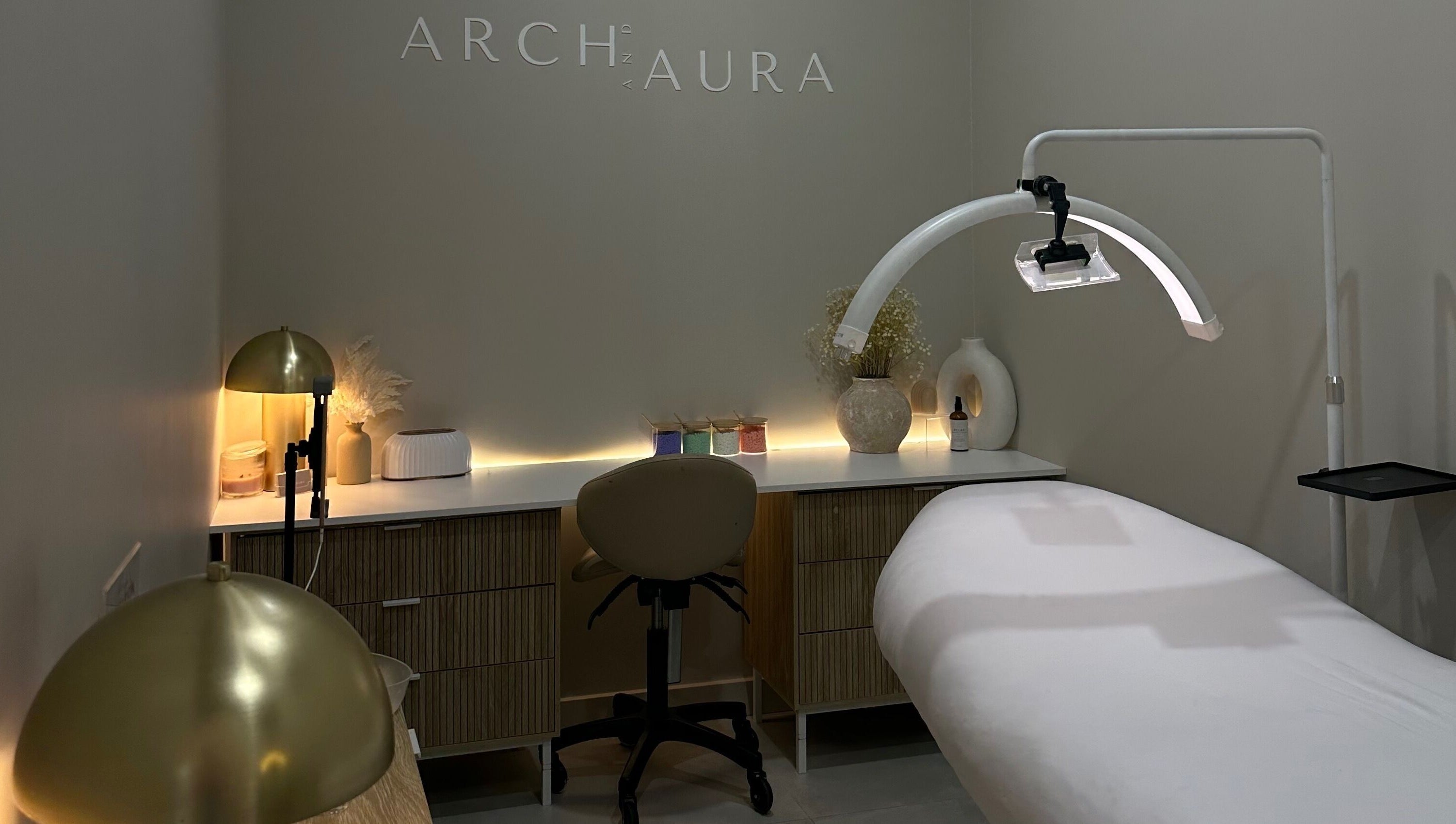 Relaxing spa room at Arch & Aura, Greystanes, New South Wales, AU with a massage table and ambient lighting.