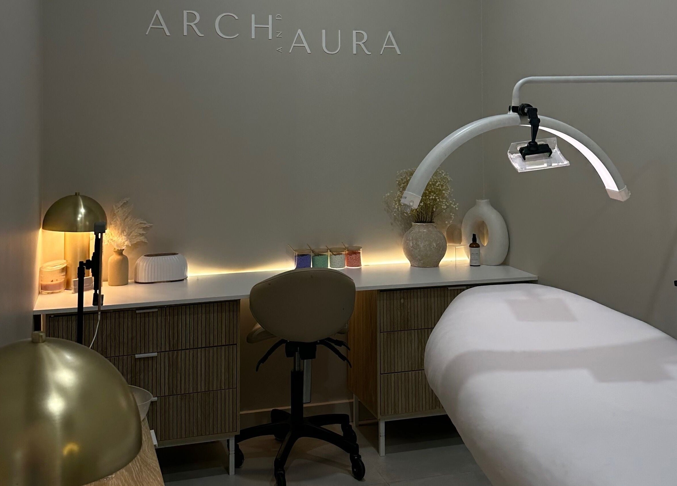 Relaxing spa room at Arch & Aura, Greystanes, New South Wales, AU with a massage table and ambient lighting.