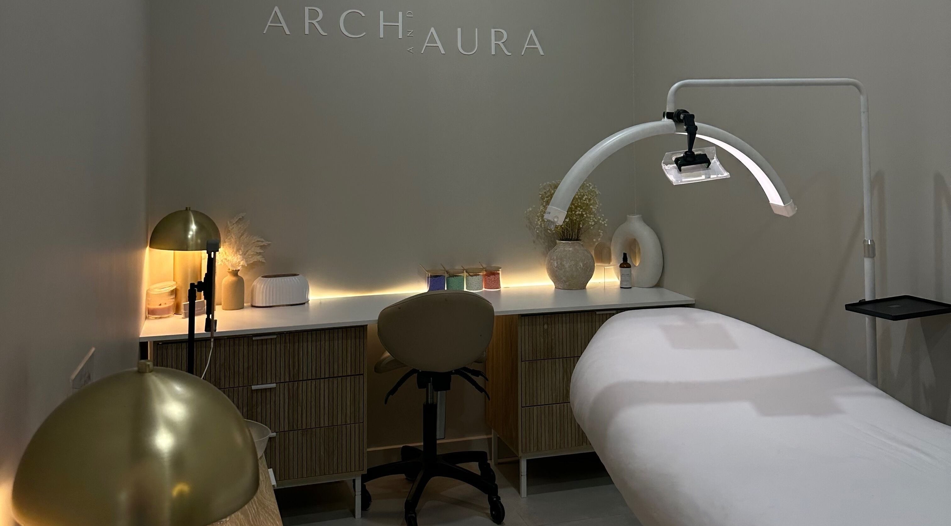 Relaxing spa room at Arch & Aura, Greystanes, New South Wales, AU with a massage table and ambient lighting.