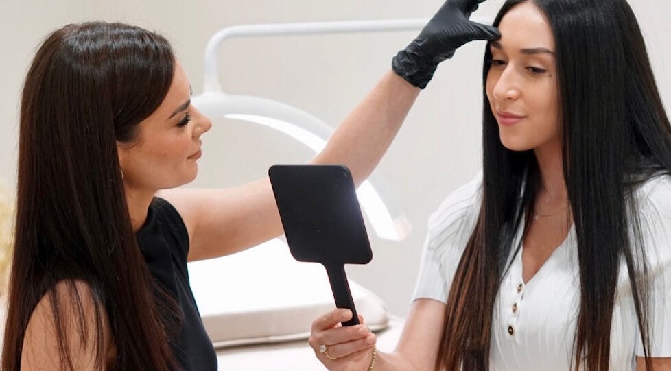 Beauty expert perfecting client's look at Arch & Aura, Greystanes, New South Wales, AU.