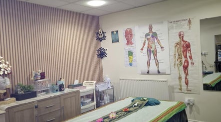 Peaceful massage room at U Sabai Massage & Spa, Newport, Wales, GB featuring anatomical charts and serene decor.