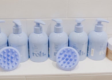 Premium haircare at KEIRAVILLE THE SALON, Keiraville, New South Wales, AU. Bottles and scalp brushes displayed.
