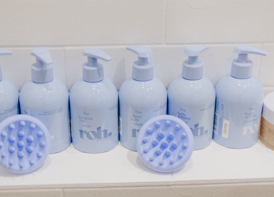 Premium haircare at KEIRAVILLE THE SALON, Keiraville, New South Wales, AU. Bottles and scalp brushes displayed.