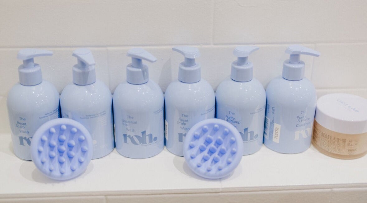 Premium haircare at KEIRAVILLE THE SALON, Keiraville, New South Wales, AU. Bottles and scalp brushes displayed.