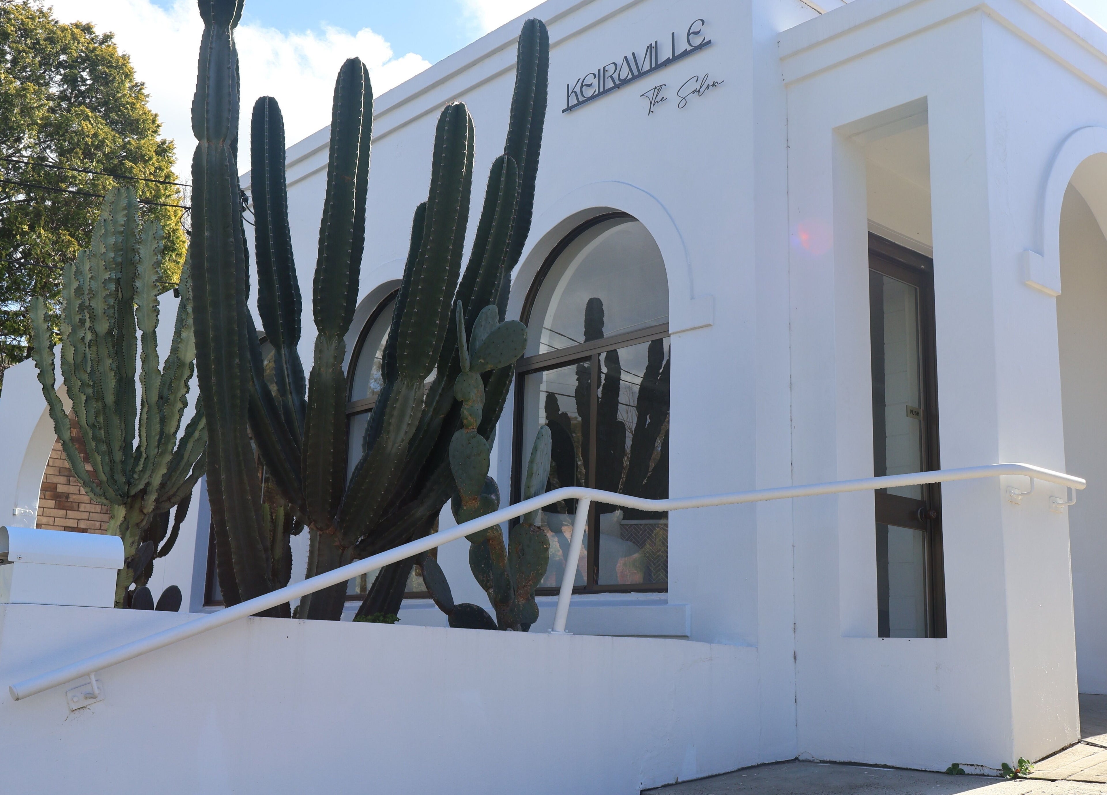 Elegant facade of KEIRAVILLE THE SALON, featuring large cacti in Keiraville, New South Wales, AU.