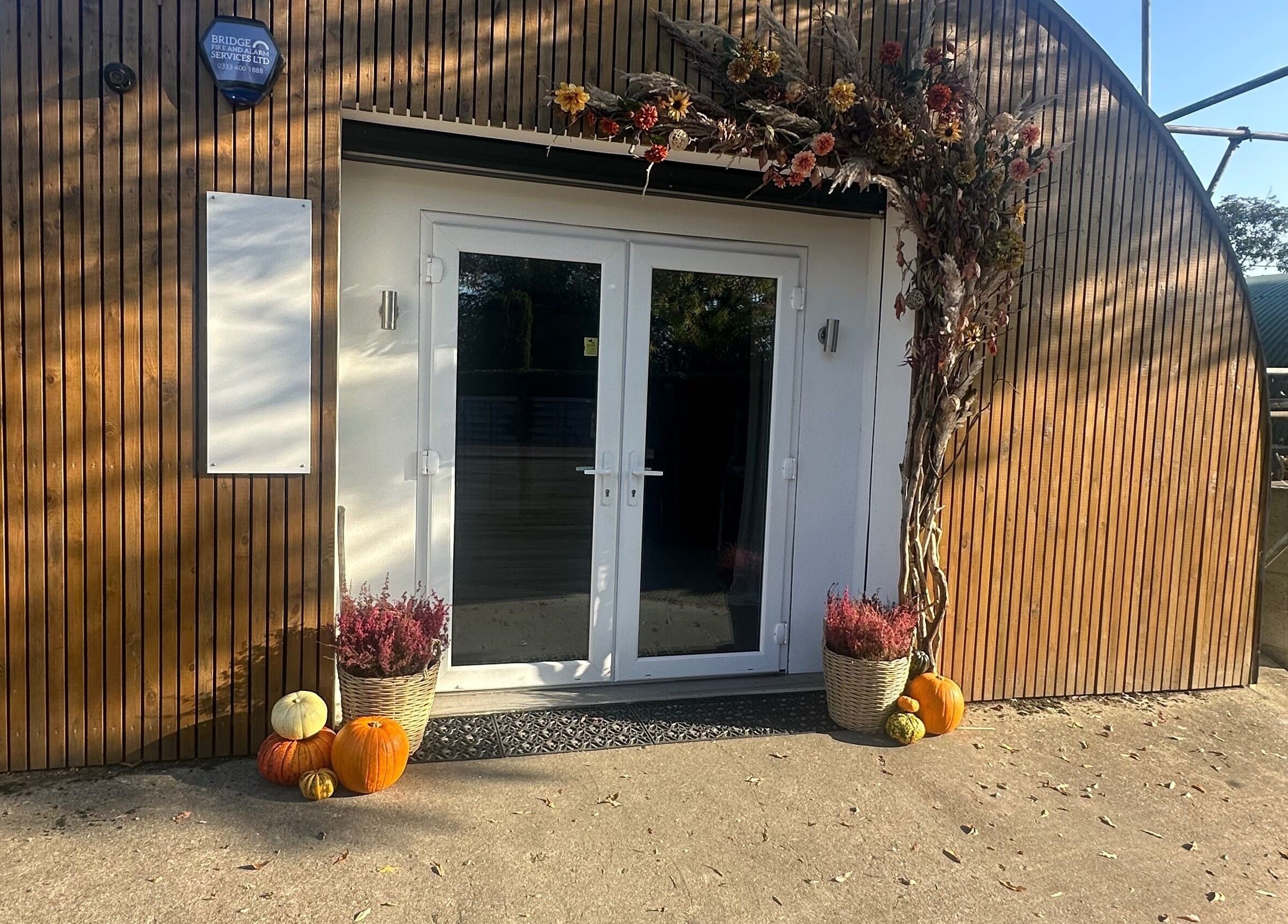 Entrance of Carley Burke Aesthetics in Bexley, England, decorated with pumpkins and flowers.