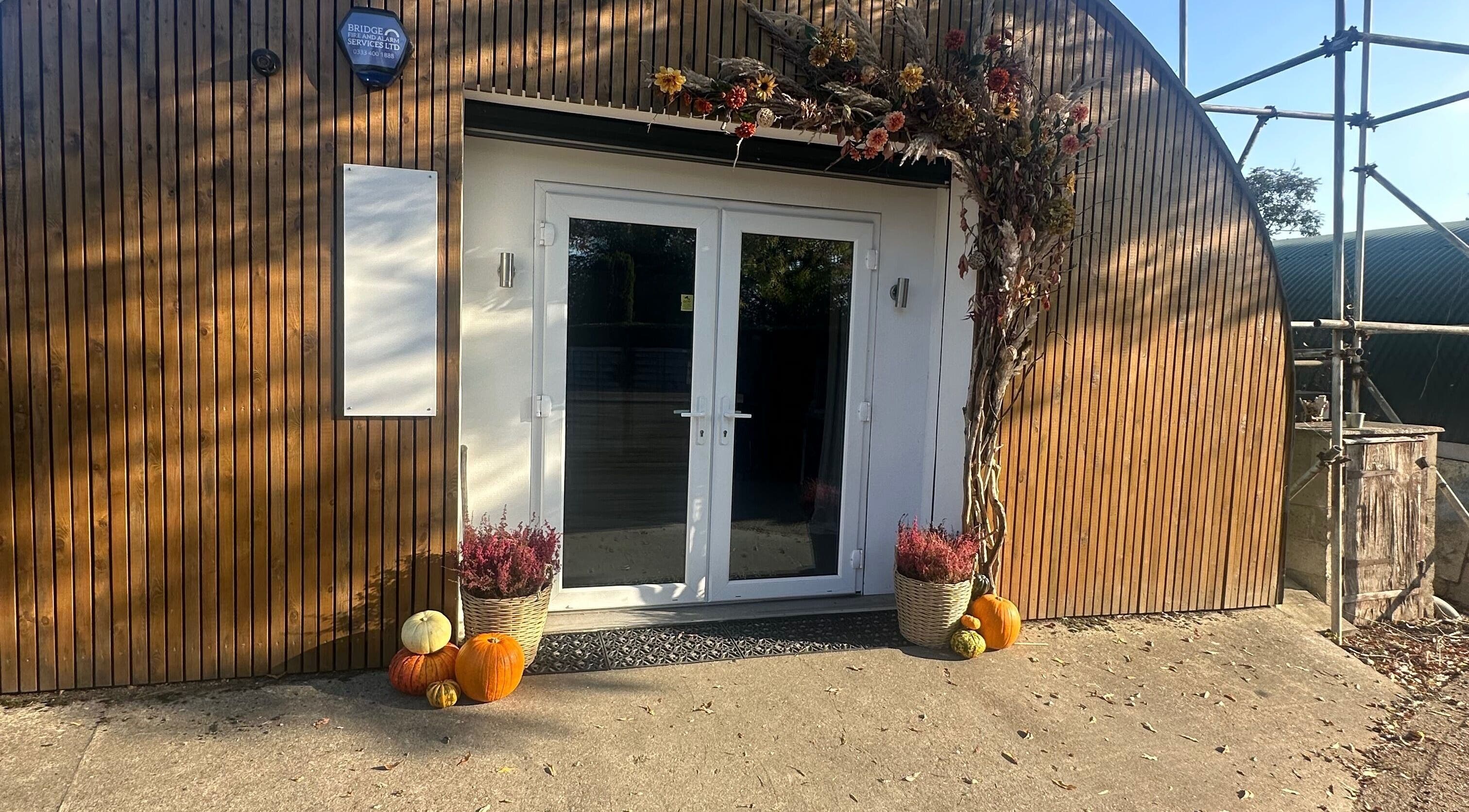 Entrance of Carley Burke Aesthetics in Bexley, England, decorated with pumpkins and flowers.