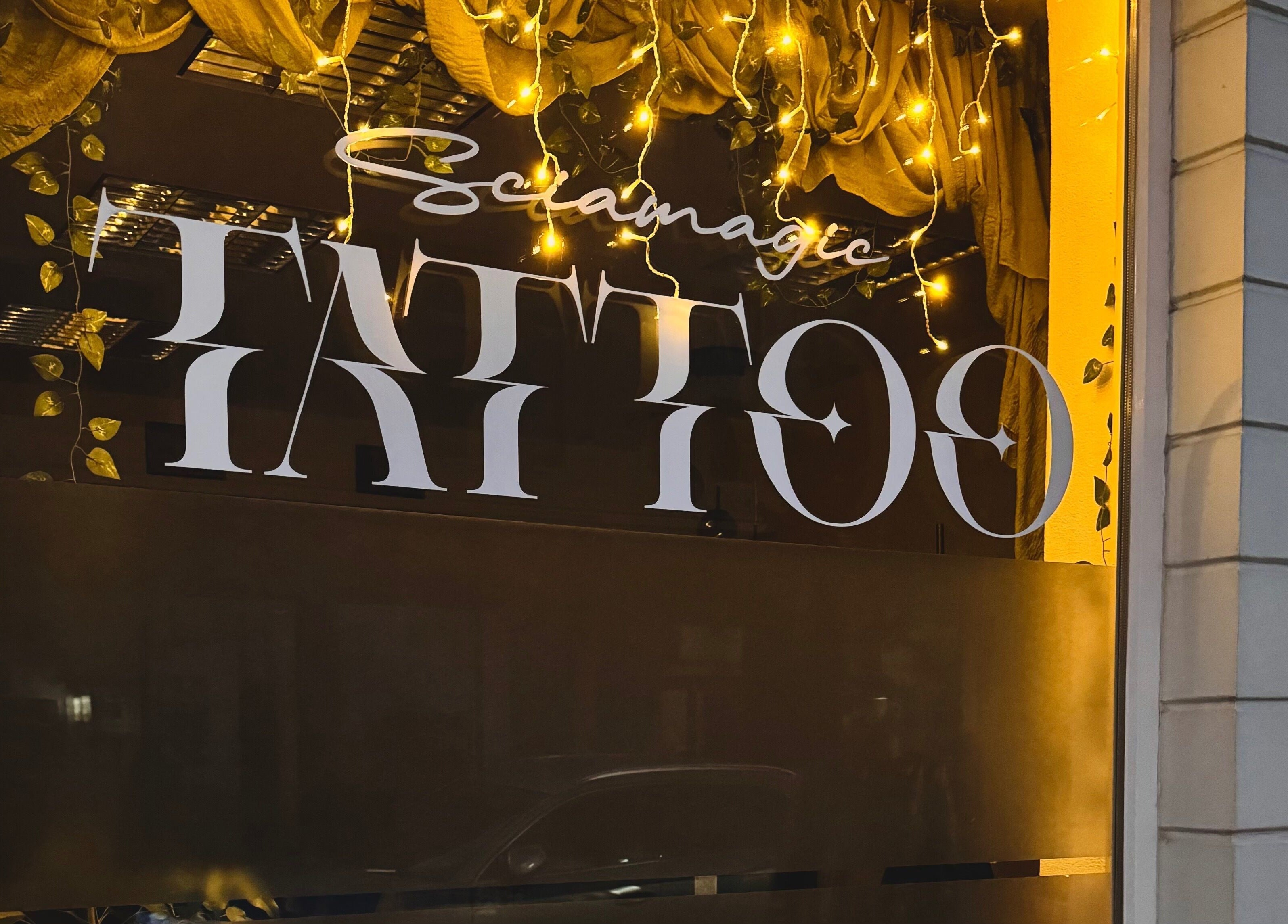 Schaufenster von Sciamagic Tattoo - Termine in Neustrelitz, Mecklenburg-Vorpommern, DE mit leuchtenden Lichtern.