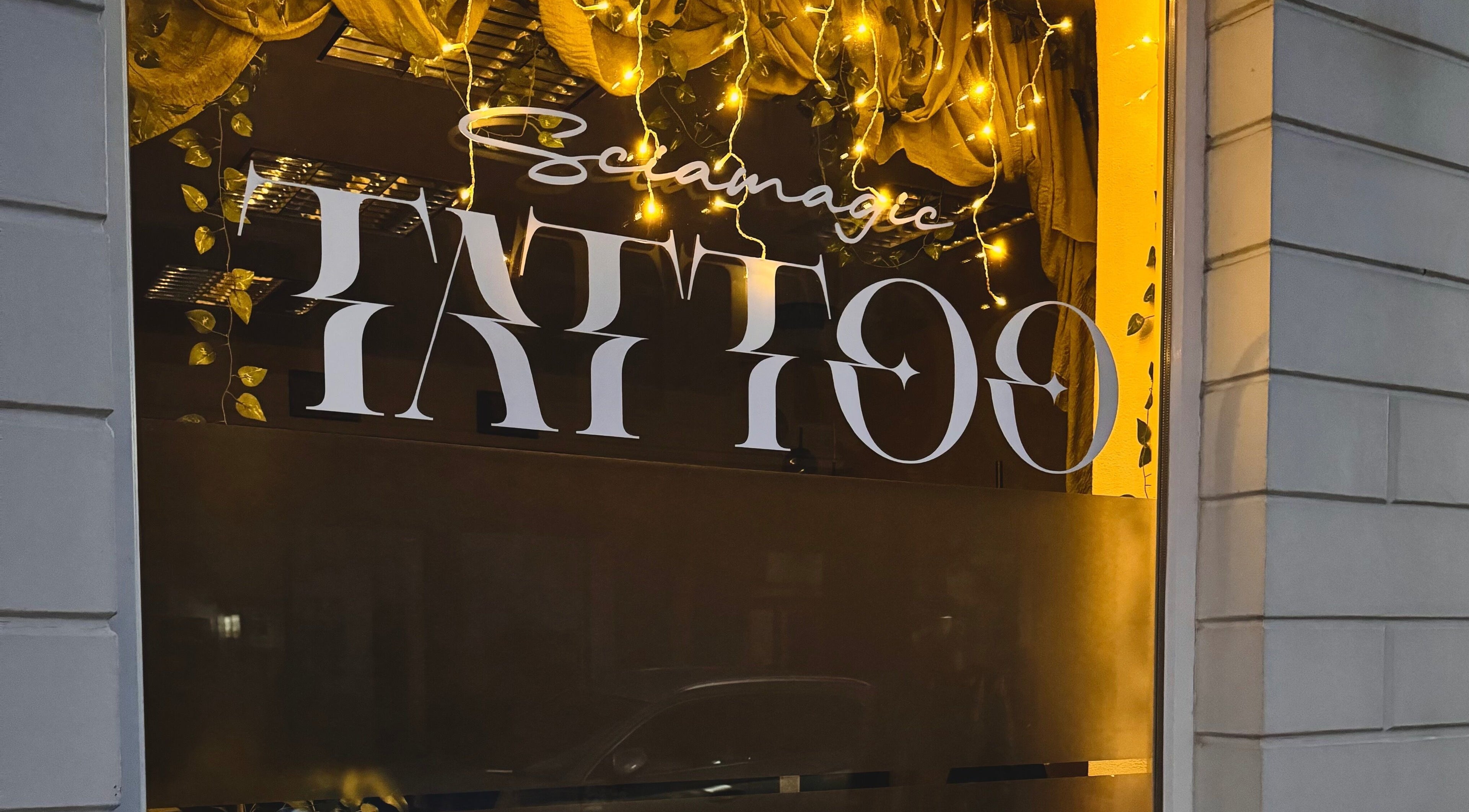 Schaufenster von Sciamagic Tattoo - Termine in Neustrelitz, Mecklenburg-Vorpommern, DE mit leuchtenden Lichtern.