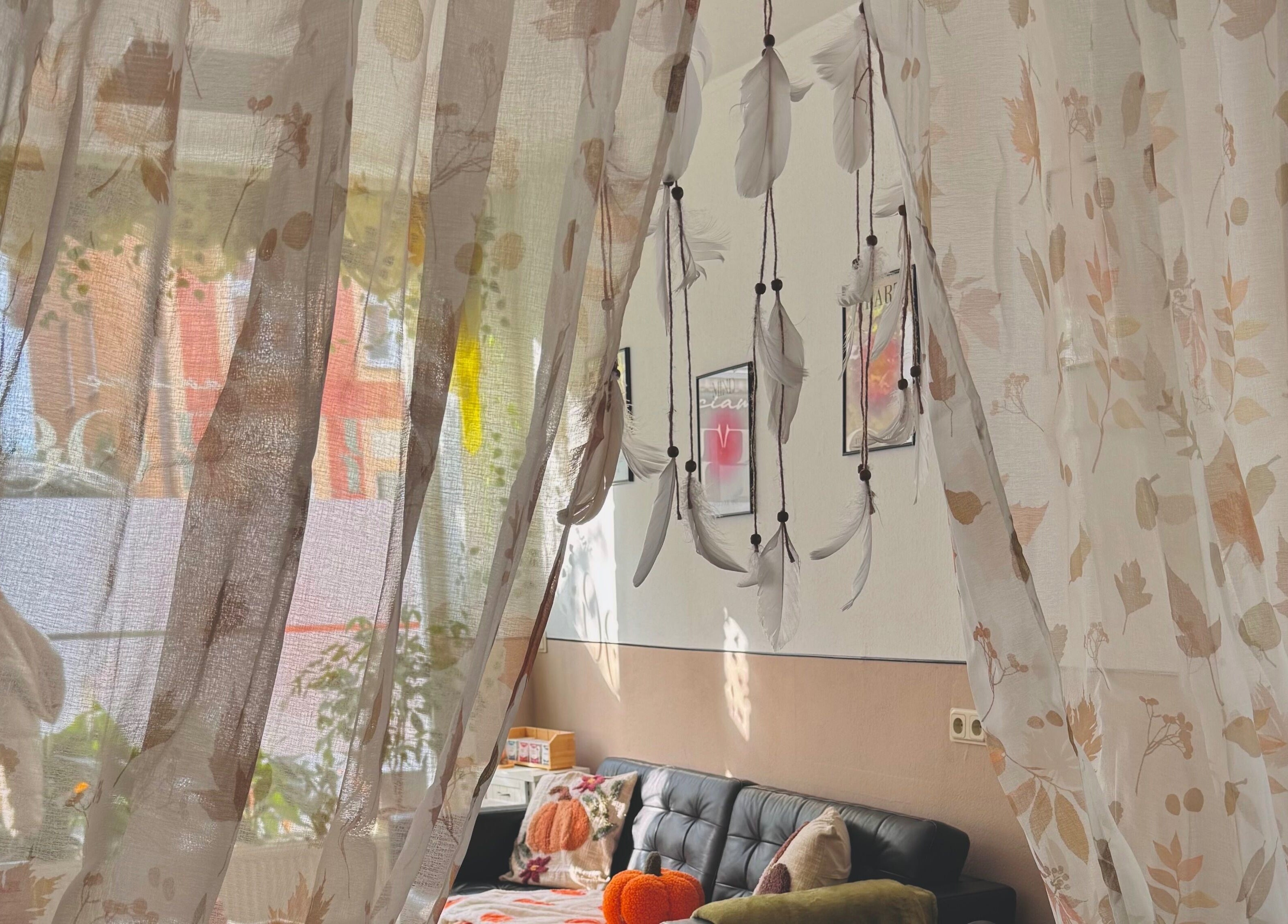 Gemütliche Ecke im Sciamagic Tattoo - Termine in Neustrelitz mit zarten Vorhängen und Federn-Dekor.