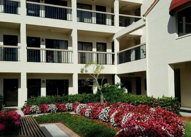 Beautiful courtyard at Naples Healing Arts in Naples, Florida, US with lush gardens and vibrant flowers.