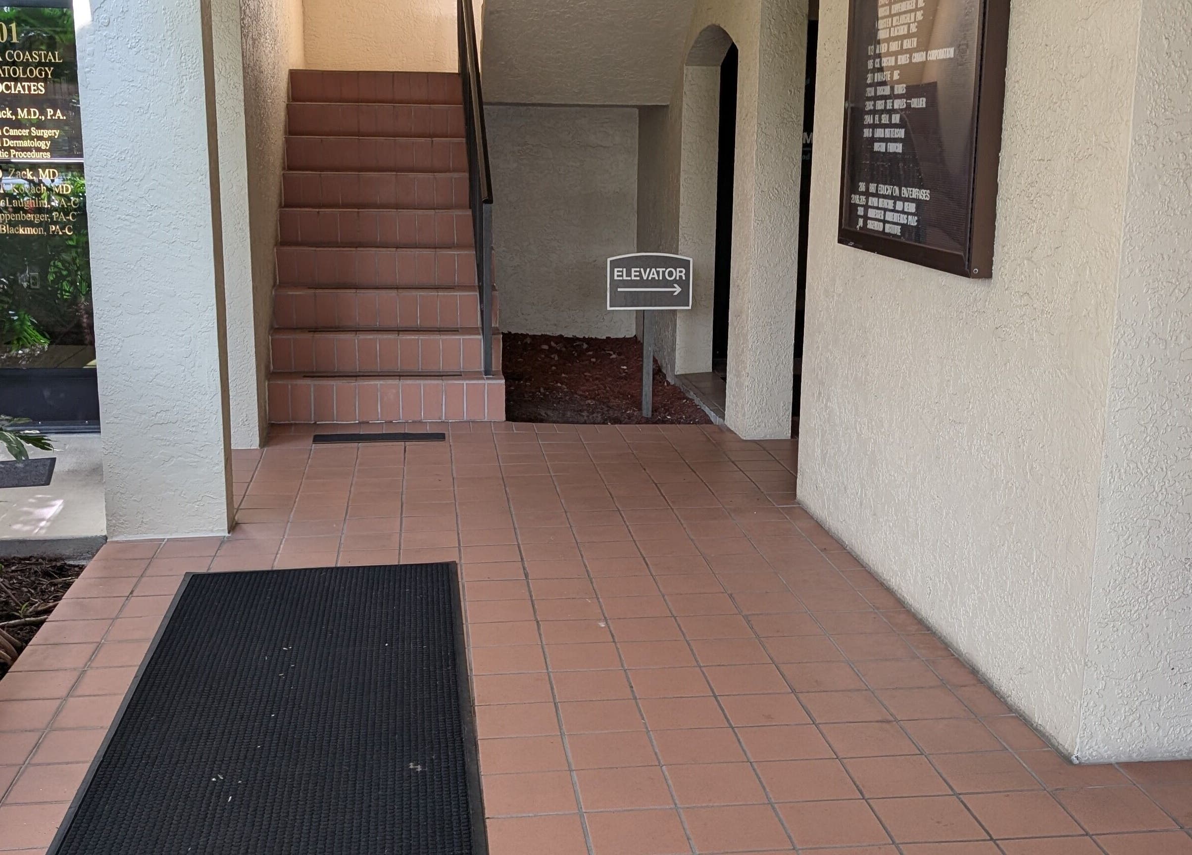 Entrance to Naples Healing Arts in Naples, Florida, US, featuring stairs and a sign to the elevator.