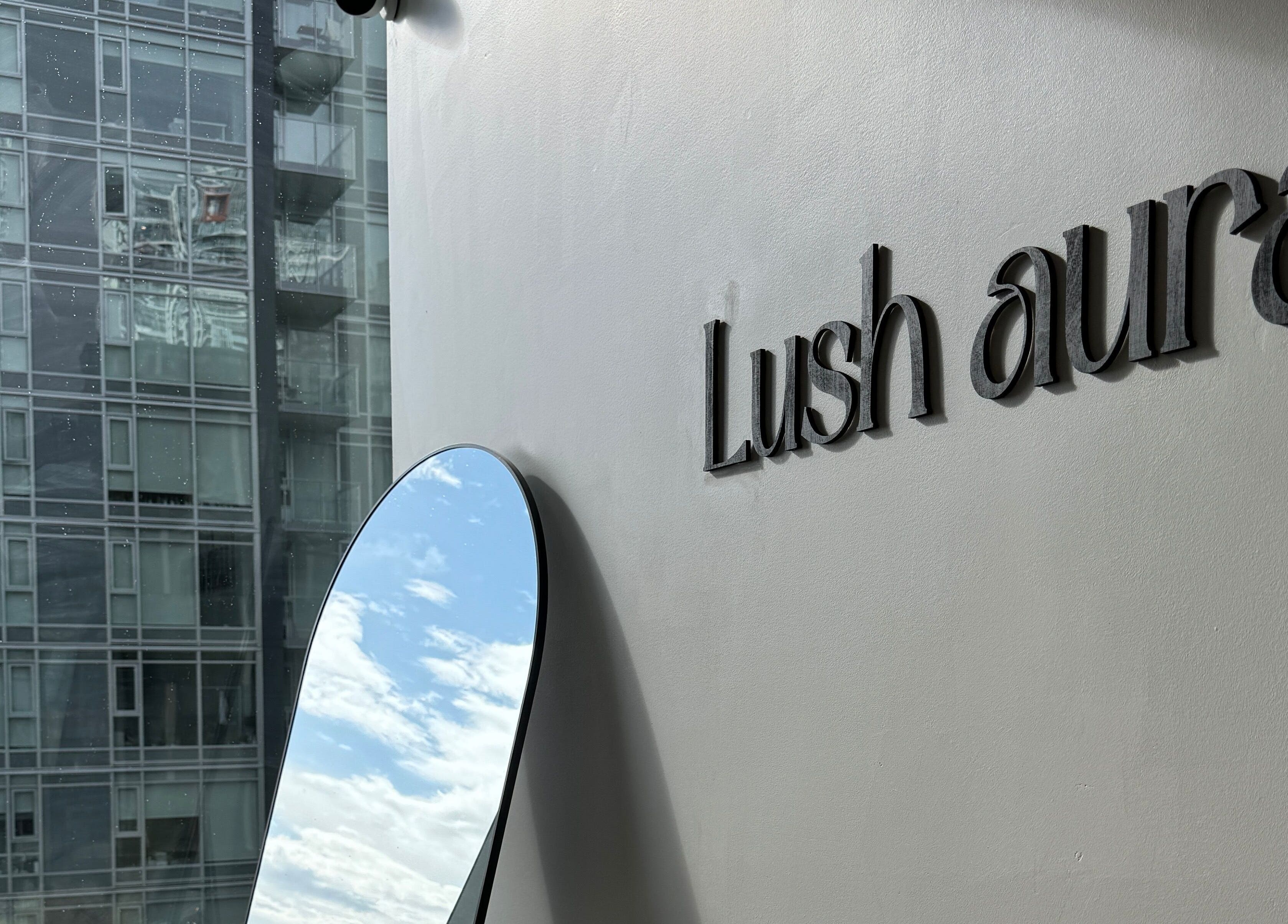 Lushaura Lash Studio exterior with logo and mirror reflecting the sky, Burnaby, British Columbia, CA.