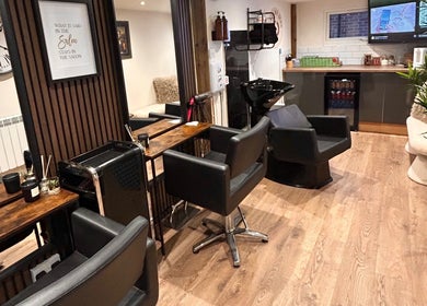 Elegant salon interior at Hair By Jess, Penllergaer, Cymru, GB, featuring stylish black chairs and modern decor.