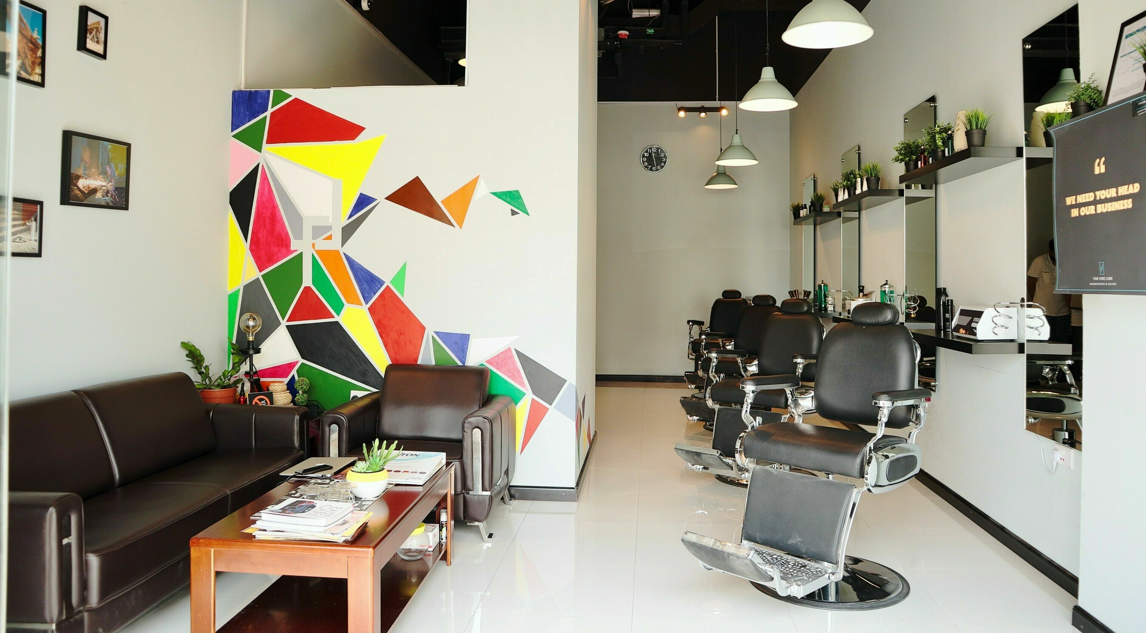 Stylish interior of The Fine Line salon in Dubai, AE featuring modern chairs and colorful wall art.