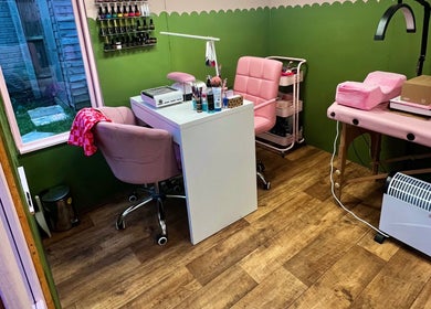 Cozy interior of Daryl’s Beauty Room in Walmer, England, featuring elegant pink chairs and nail care tools.