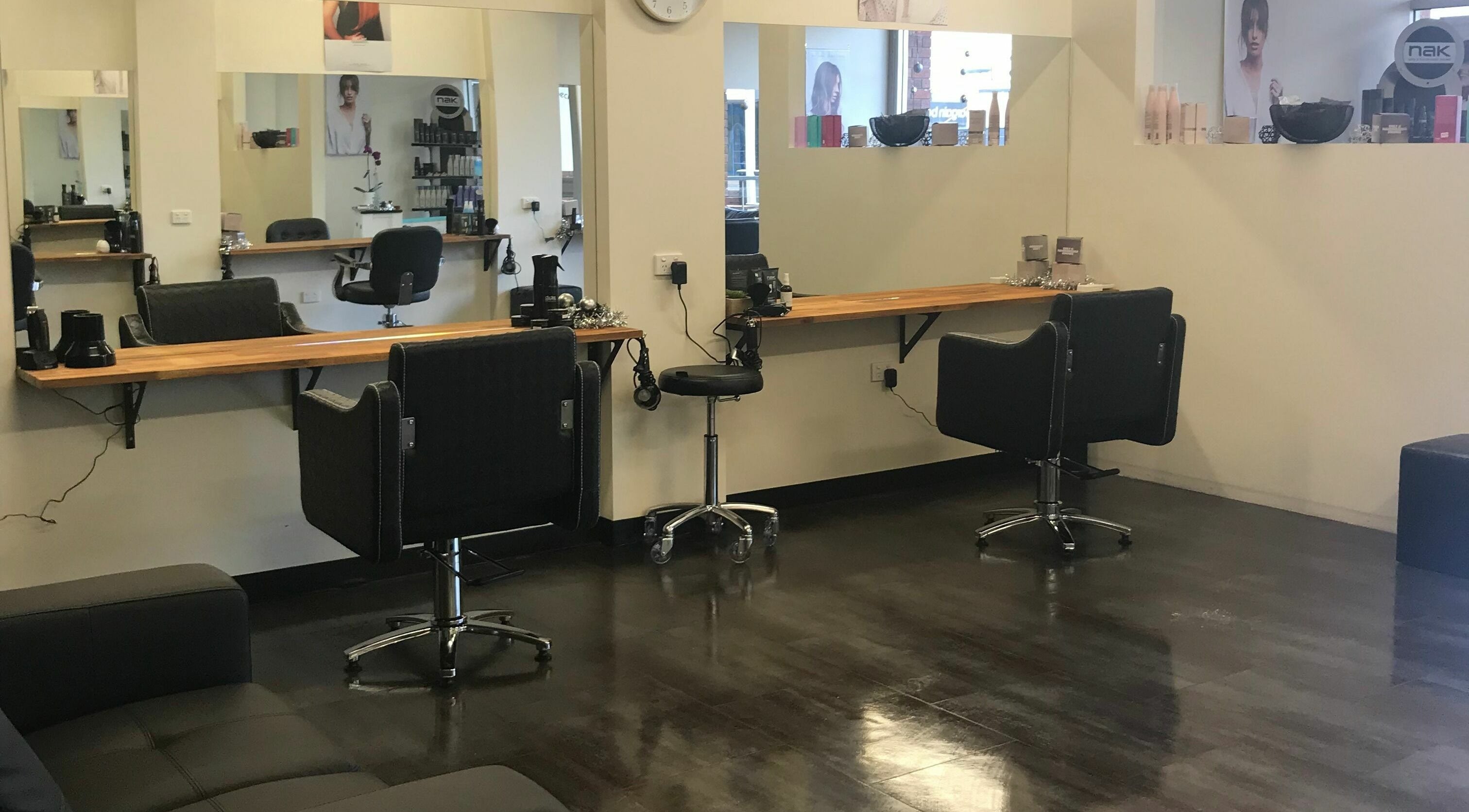Modern salon interior at Teazed, Scottsdale, Tasmania, AU featuring sleek black styling stations and large mirrors.