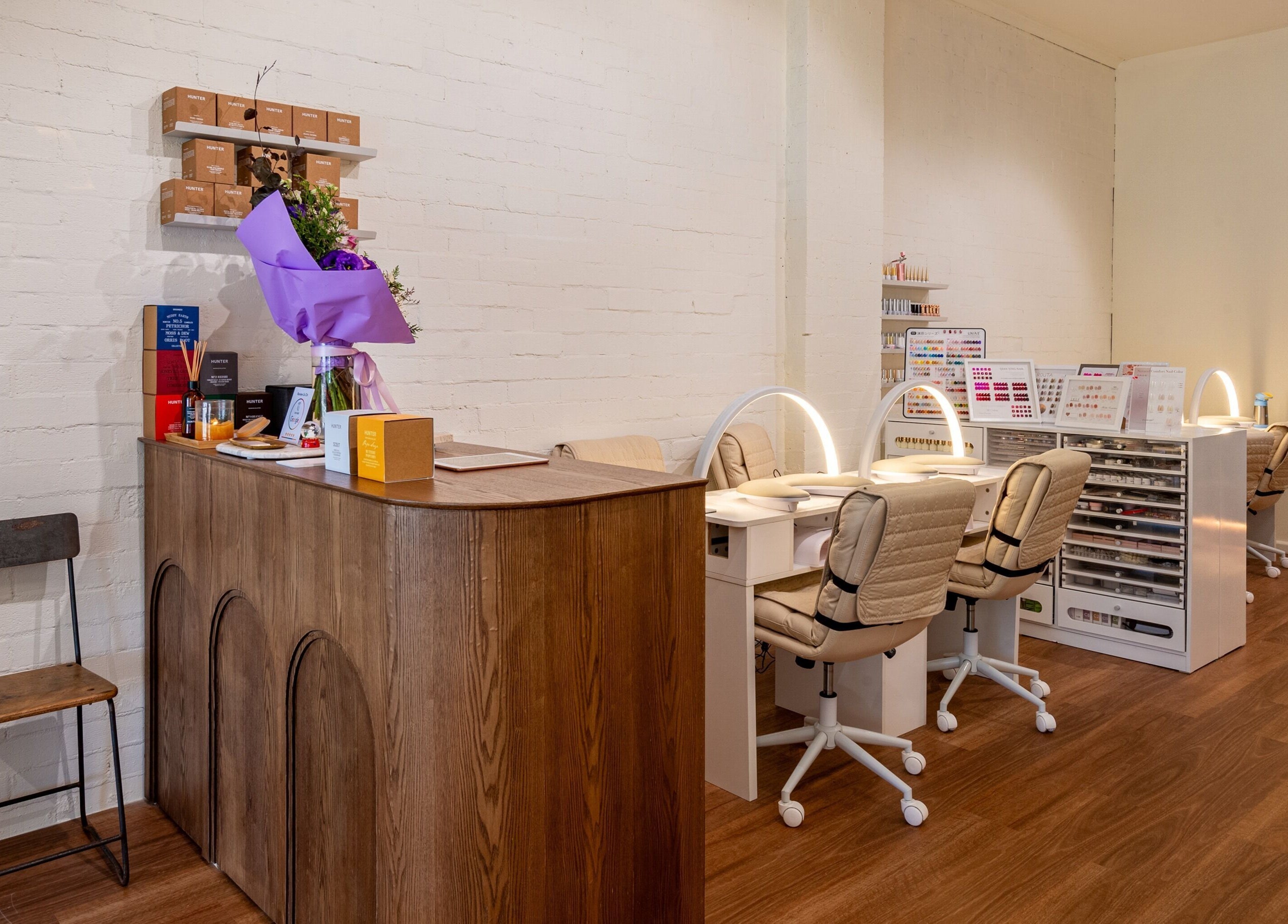 Reception area and nail stations at Vaness Salon, Caringbah, New South Wales, AU, with modern decor and lighting.