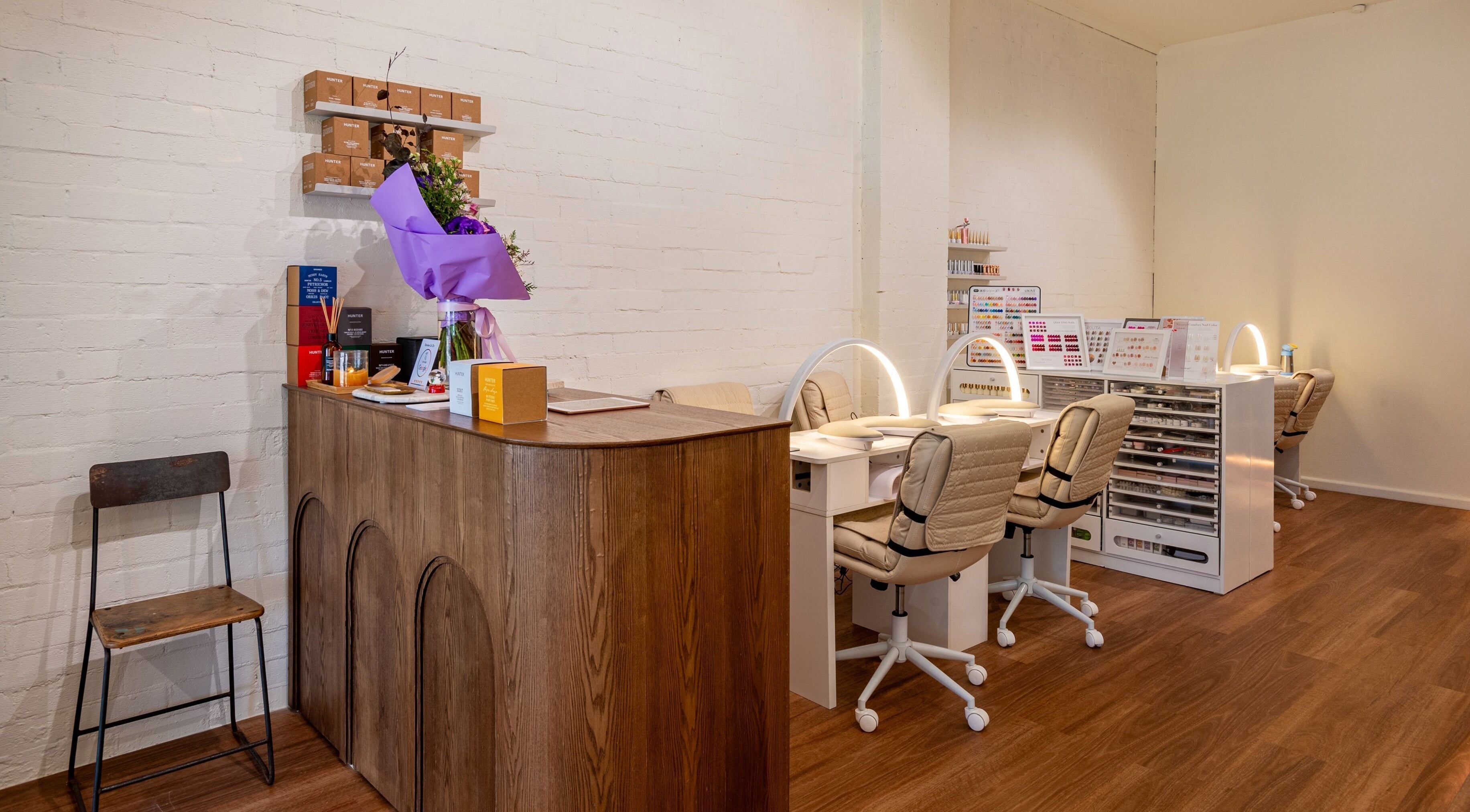 Reception area and nail stations at Vaness Salon, Caringbah, New South Wales, AU, with modern decor and lighting.