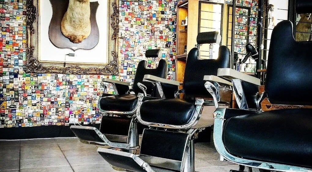 Stylish interior of The Parnell BarberShop in Auckland, NZ showcasing vintage barber chairs and unique wall decor.