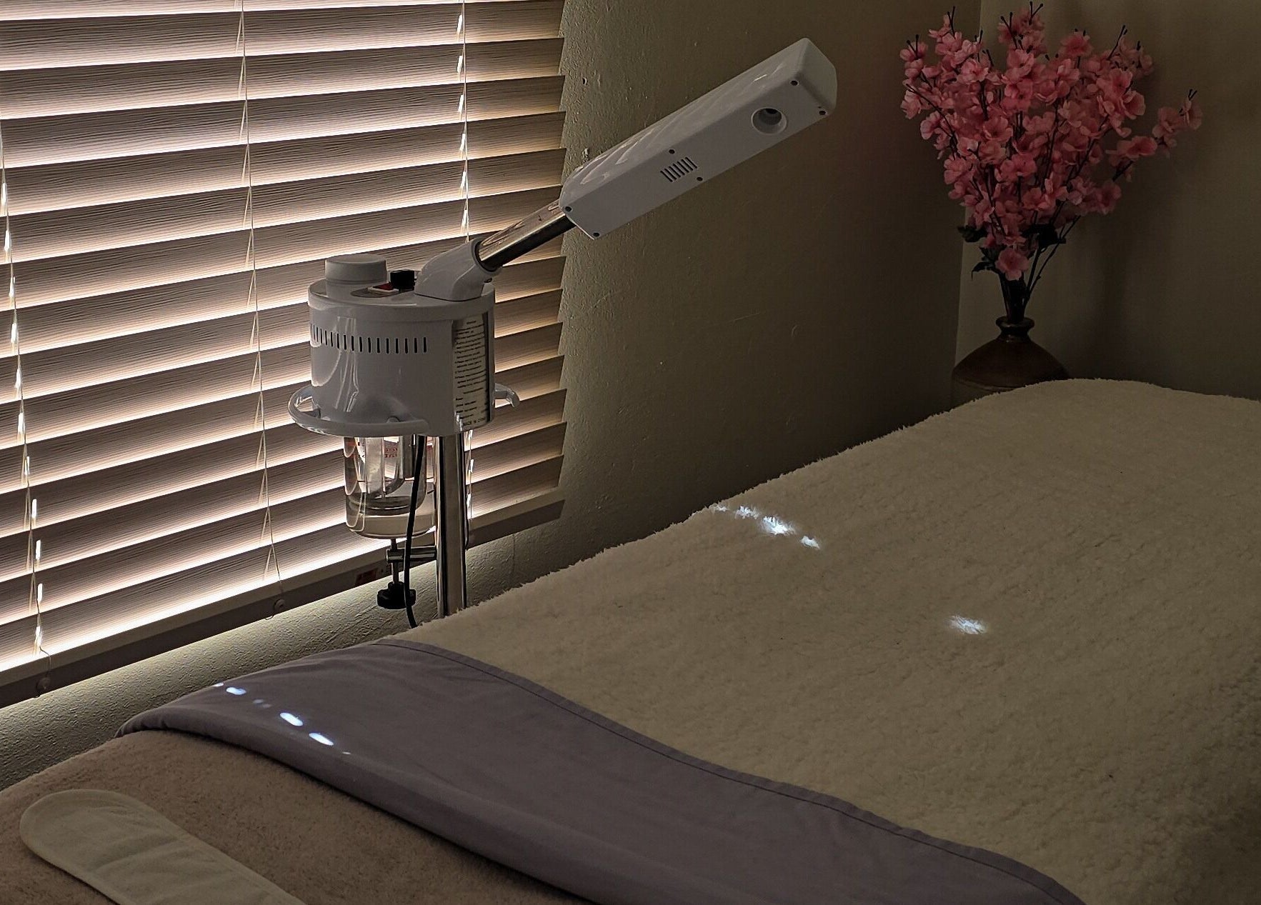 Relaxing spa room at Whispering Waters, Bloemfontein, Free State, ZA featuring a massage table and floral decor.