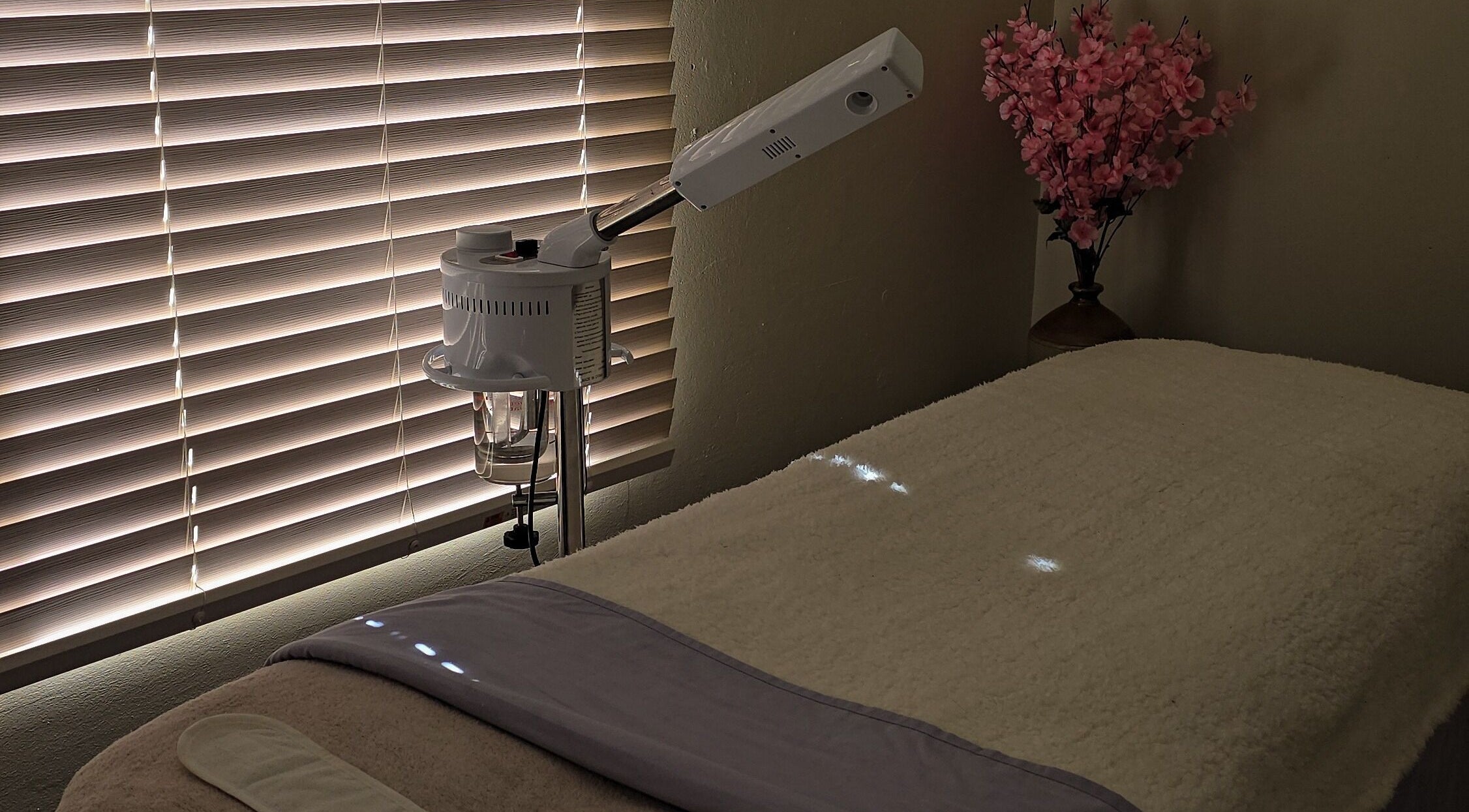 Relaxing spa room at Whispering Waters, Bloemfontein, Free State, ZA featuring a massage table and floral decor.