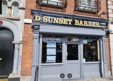 Entrance of Sunset Barber Salon at Dublin 1, County Dublin, IE. Classic facade with vibrant signage.
