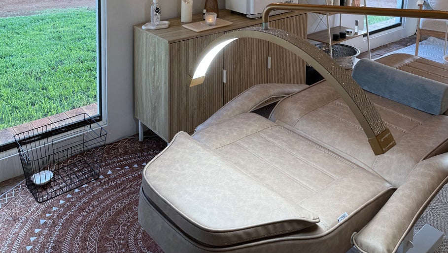 Luxurious spa bed at Tiarne Lauren Beauty in Vasse, Western Australia, AU next to large window with a green view.