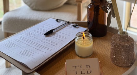 Cozy welcome setup at Tiarne Lauren Beauty, Vasse, Western Australia, featuring a candle, clipboard, and decor.