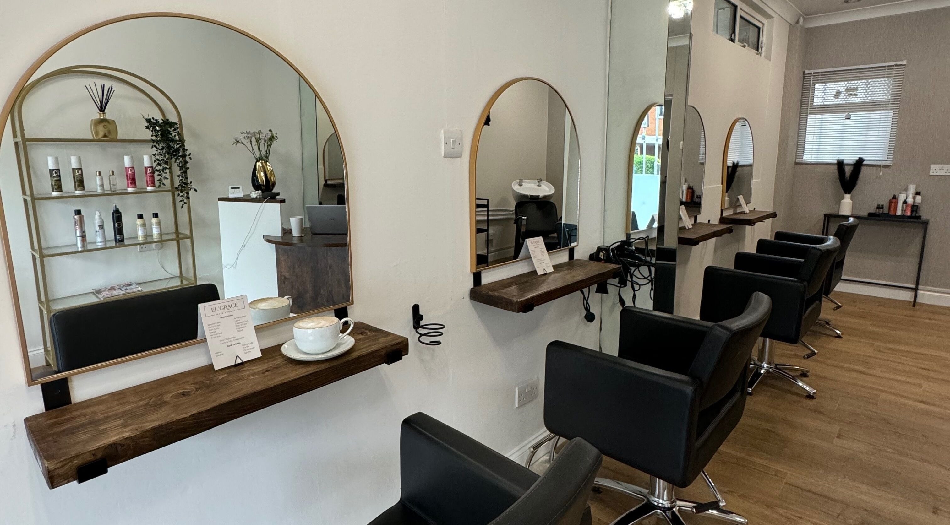 Interior view of Elgrace Hair Studio in Luton, England, GB with stylish salon chairs and mirrors.