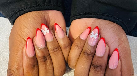 Stylish red-tipped manicure with floral accents at Priscillas beauty spot in Pretoria, Gauteng, ZA.