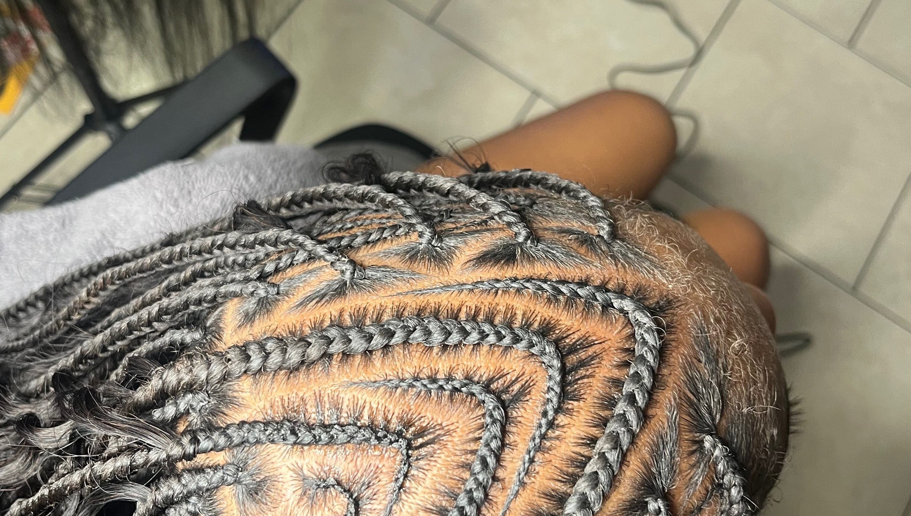 Close-up of intricate braids at Berry’s Roots in Opa-locka, Florida, US, showcasing expert hairstyling.