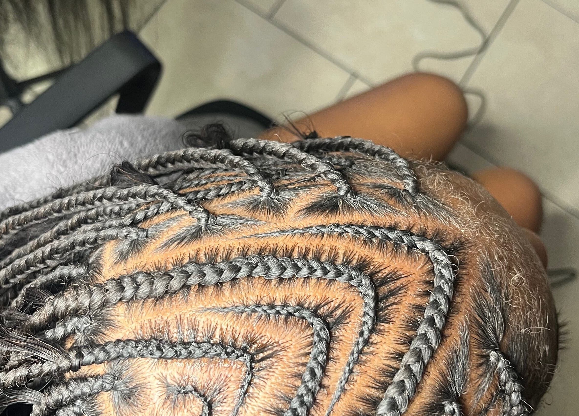 Close-up of intricate braids at Berry’s Roots in Opa-locka, Florida, US, showcasing expert hairstyling.