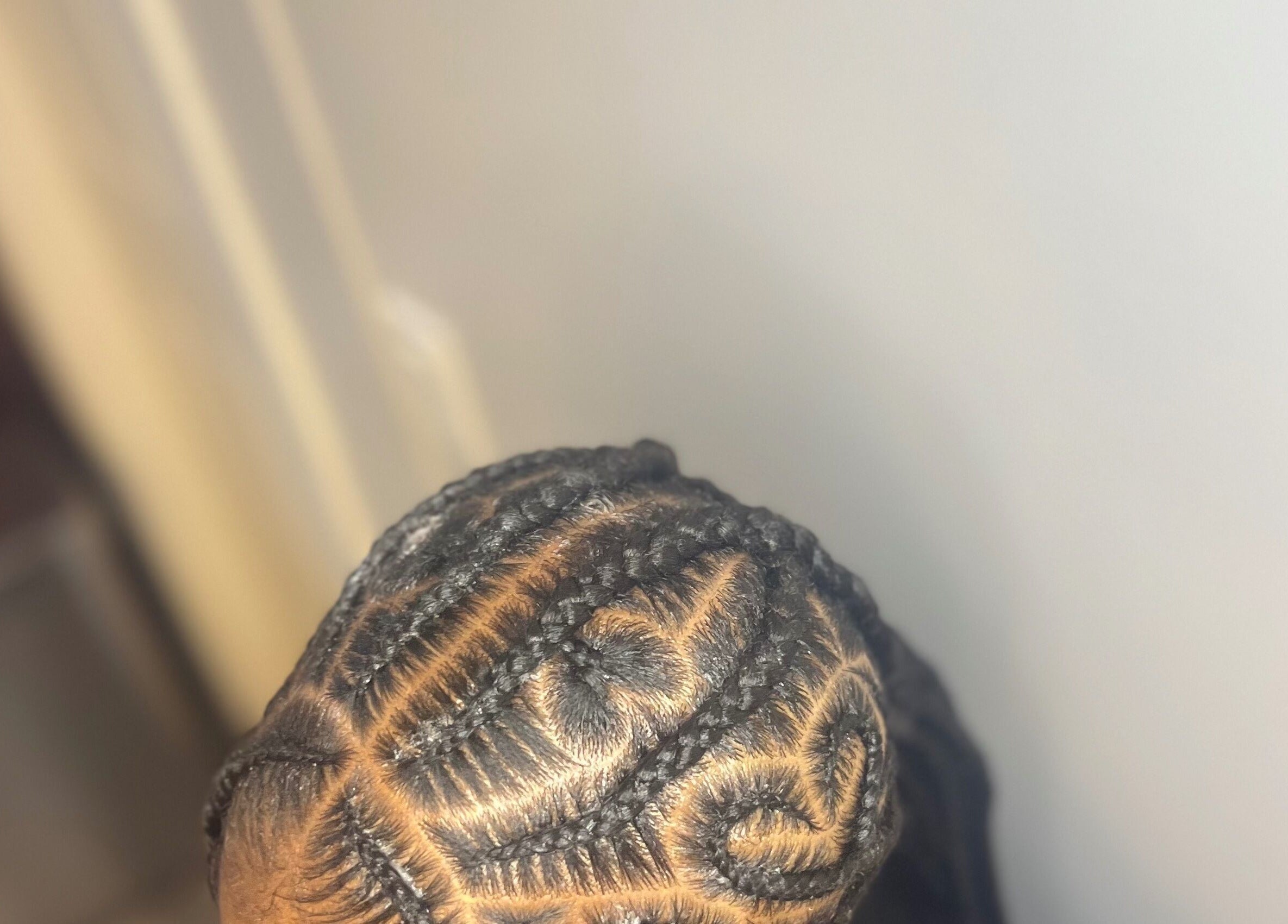 Intricate cornrow hairstyle at Berry’s Roots, Opa-locka, Florida, US, showcasing detailed braid patterns.