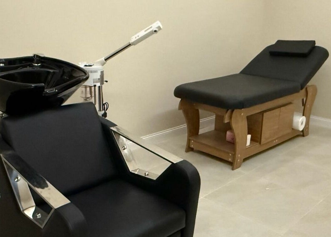 Relaxation room at Tawazun Spa, Riyadh, features a modern massage table and shampoo chair for ultimate comfort.