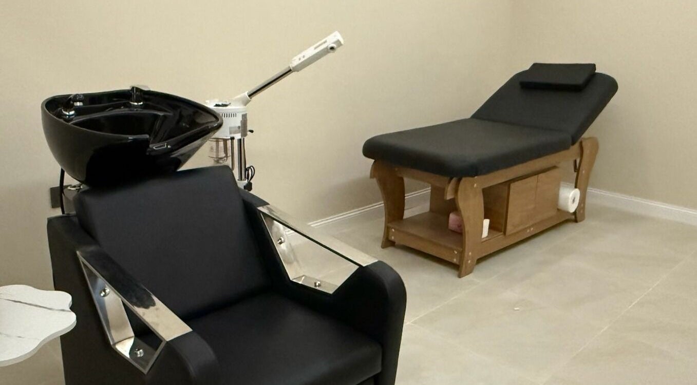 Relaxation room at Tawazun Spa, Riyadh, features a modern massage table and shampoo chair for ultimate comfort.