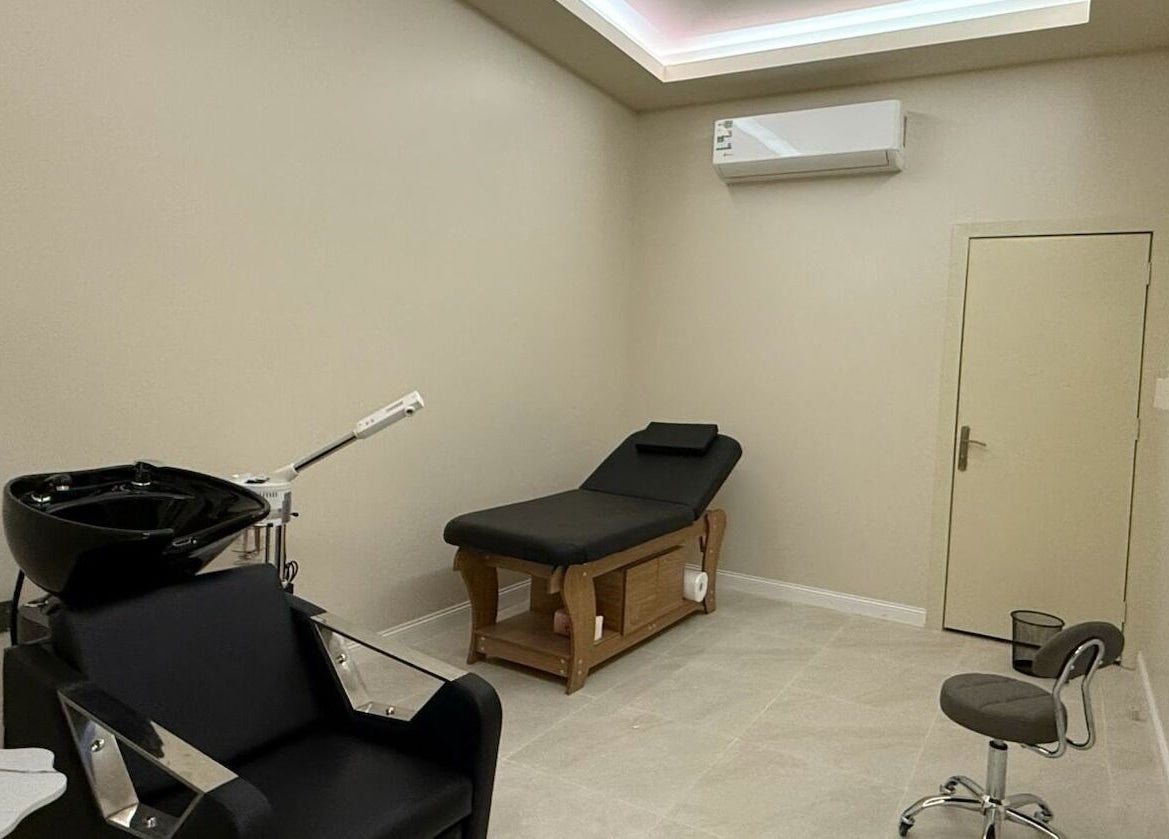Modern therapy room at Tawazun Spa in Riyadh, Riyadh Province, SA, featuring a massage bed and styling chair.