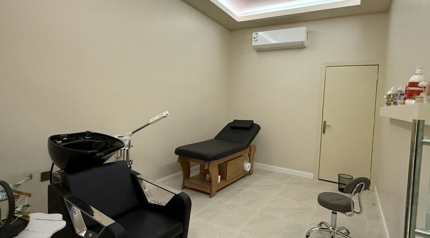 Modern therapy room at Tawazun Spa in Riyadh, Riyadh Province, SA, featuring a massage bed and styling chair.